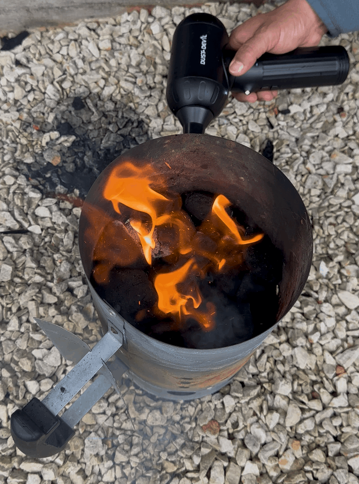using dustdevil air duster to burst high-pressure air helps ignite coals faster by increasing oxygen flow.