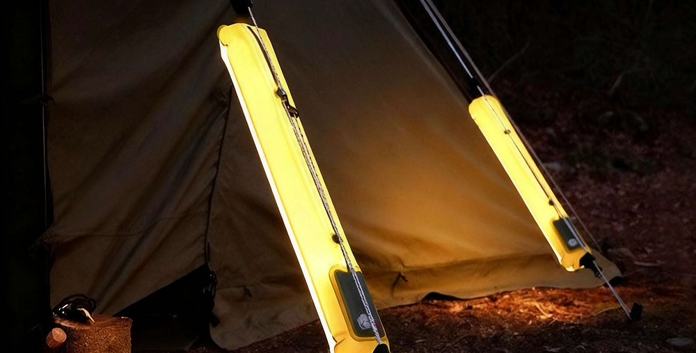Yellow camping light attached to a tent in a dark outdoor setting