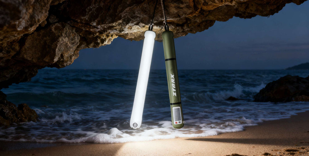 Two light tubes hanging from a rock over a beach with ocean waves.