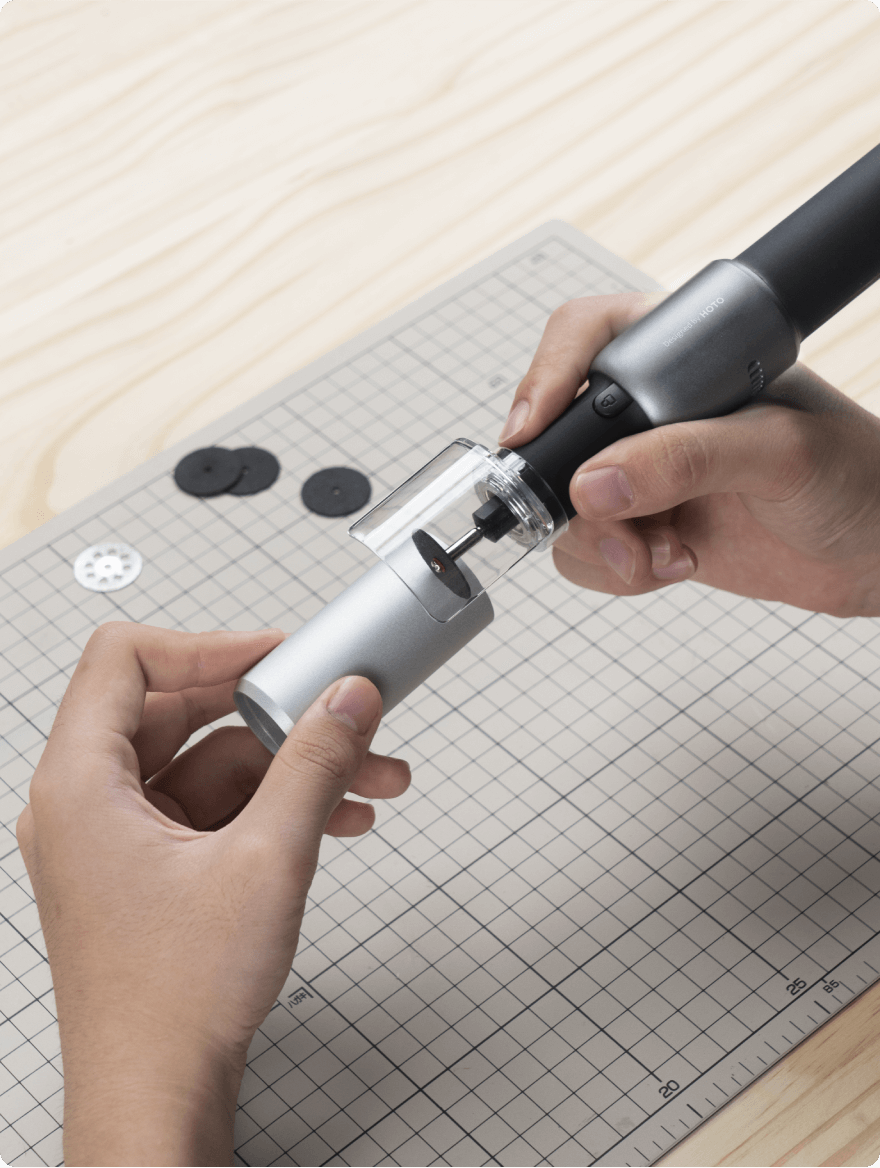 Person using a tool on a cutting mat with grid lines