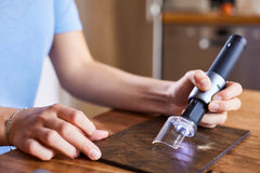 Person using a handheld tool on a wooden surface