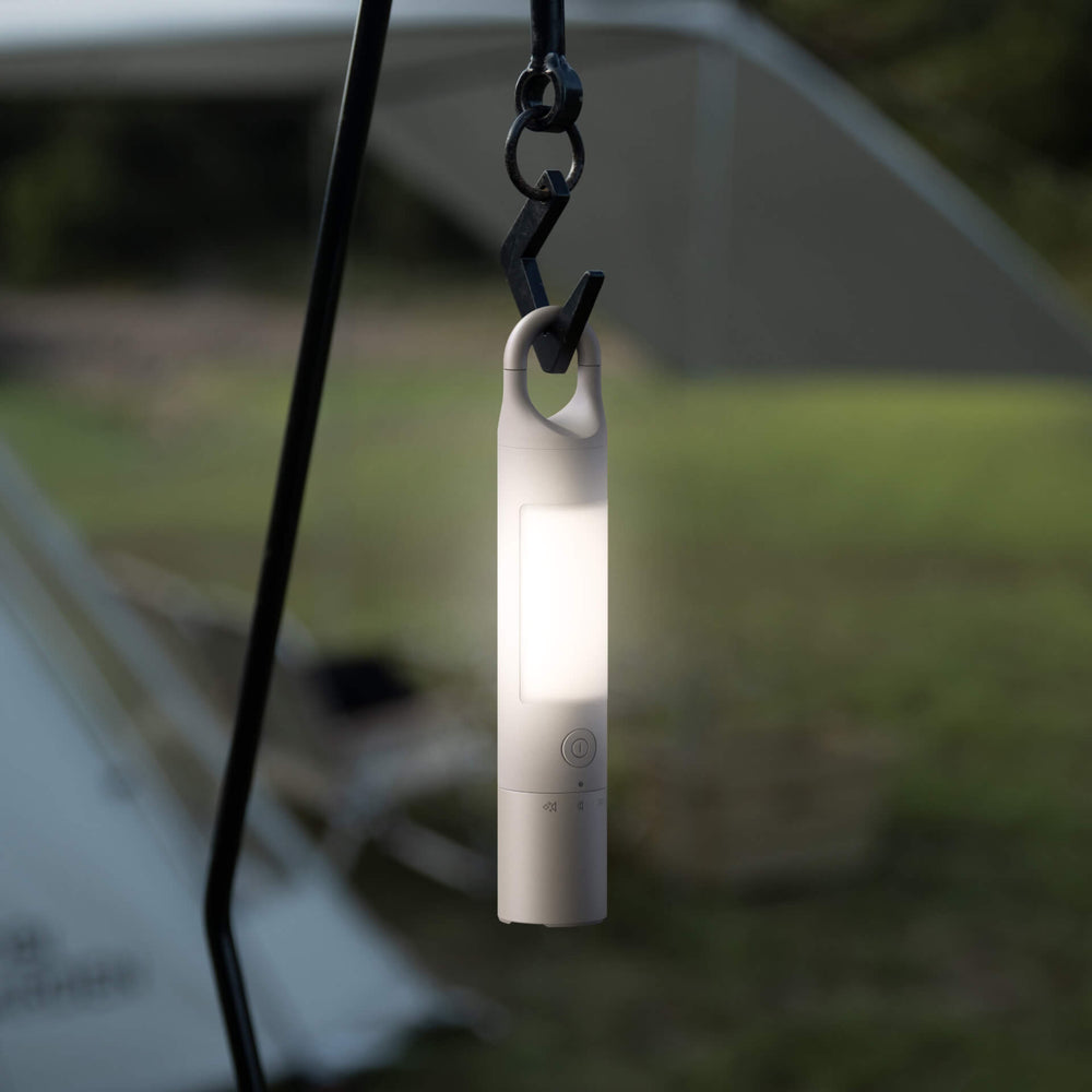 Portable light hanging from a hook with a blurred outdoor background