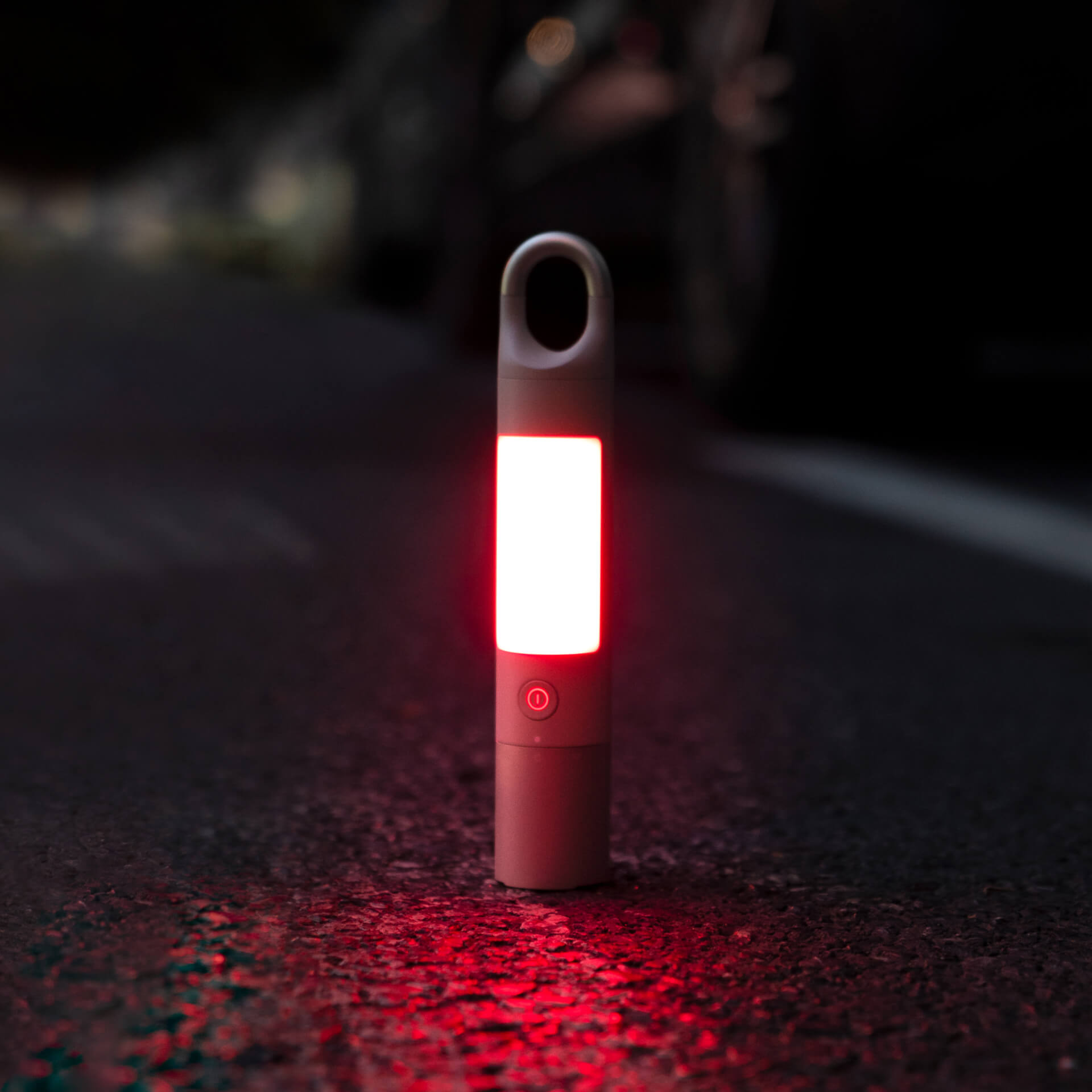 Red flashlight on a dark surface with blurred background