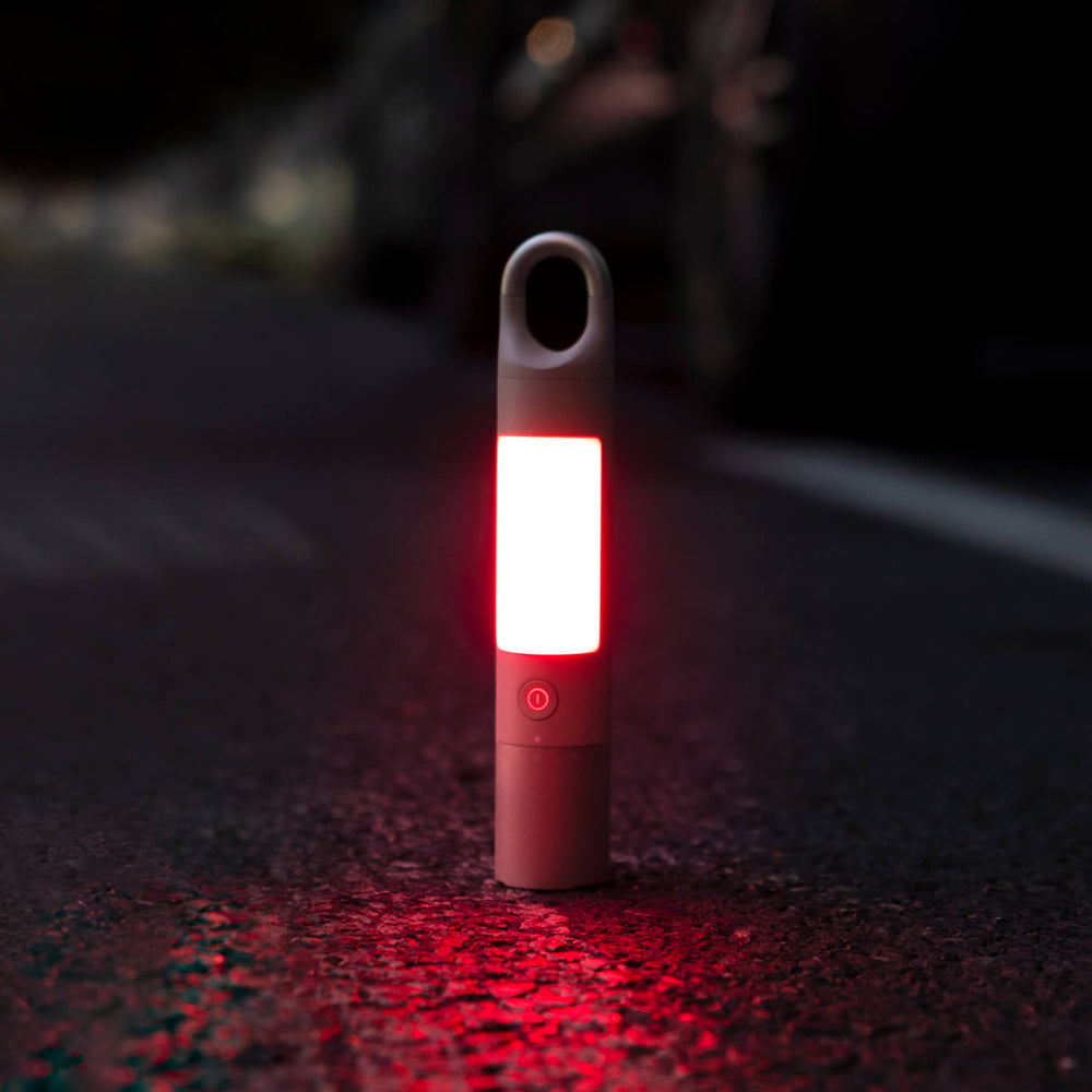 Red flashlight on a dark surface with blurred background