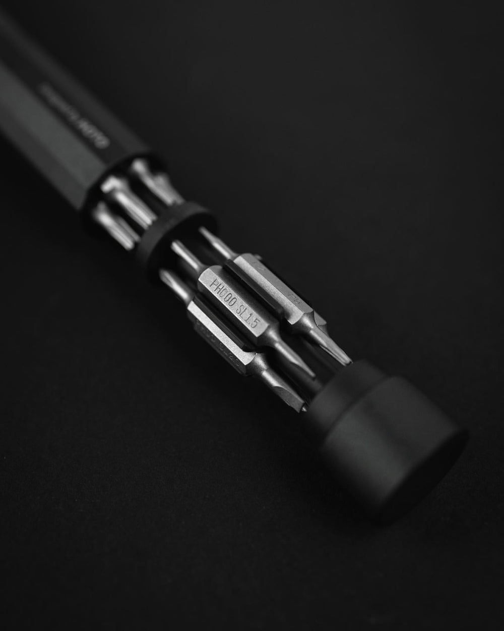 Close-up of a multi-bit screwdriver on a black background