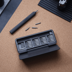 Black screwdriver set with bits on a cork surface