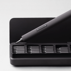 Black screwdriver set with multiple bits on a white background