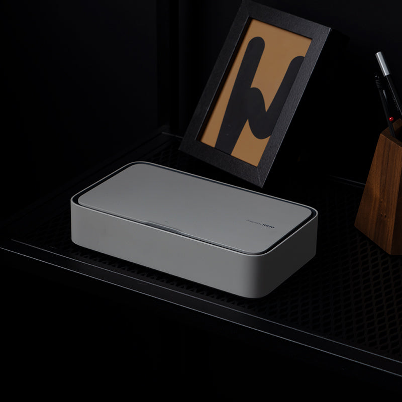 Gray rectangular box on a dark surface with a blurred background