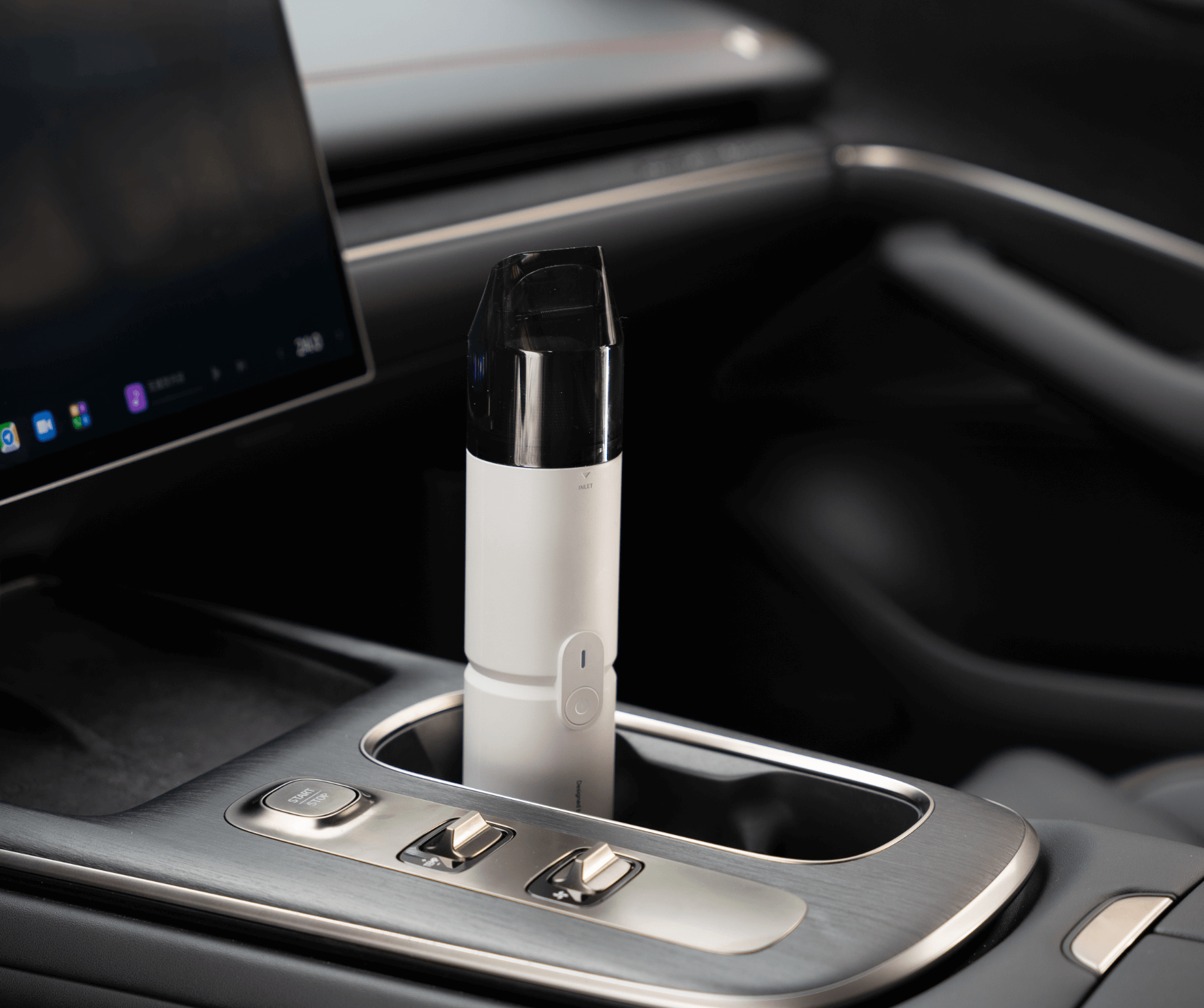 Car cup holder with a white electronic device inside, likely a vape pen, on a dark interior background.