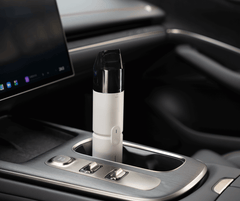 Car cup holder with a white electronic device inside, likely a vape pen, on a dark interior background.