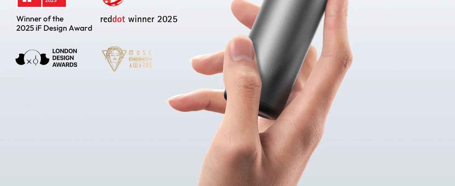 Hand holding a black cylindrical device with design awards text on a light gray background